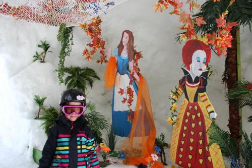 a young child standing in front of a wall with statues at Appartement Flora in Saas-Almagell