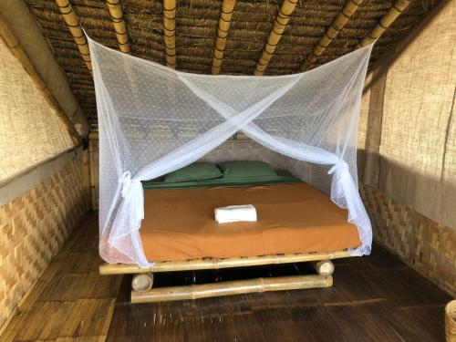 a bed in a tent in a room at Bamboo & B in Licin