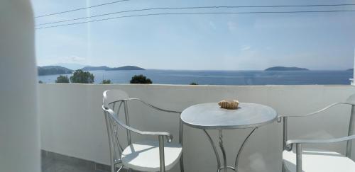 a table and chairs on a balcony with a view of the ocean at Amaranthos Skiathos View in Megali Ammos