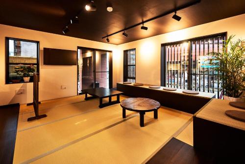 a lobby with a table and benches and windows at Guest House Wagokoro in Tokyo
