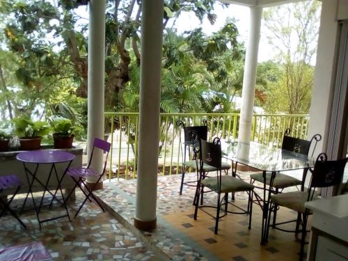 une terrasse couverte avec une table et des chaises. dans l'établissement Villa Les Violettes, à Morne-à-lʼEau