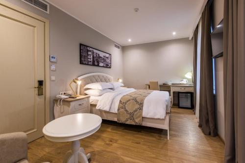 a bedroom with a bed and a desk and a table at Hotel Khokhobi Old Tbilisi in Tbilisi City