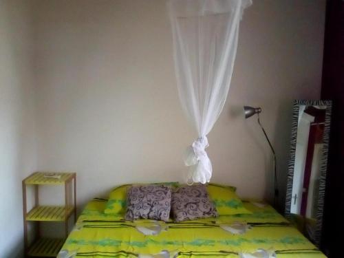 - une chambre avec un lit et un rideau au-dessus dans l'établissement Villa Les Violettes, à Morne-à-lʼEau