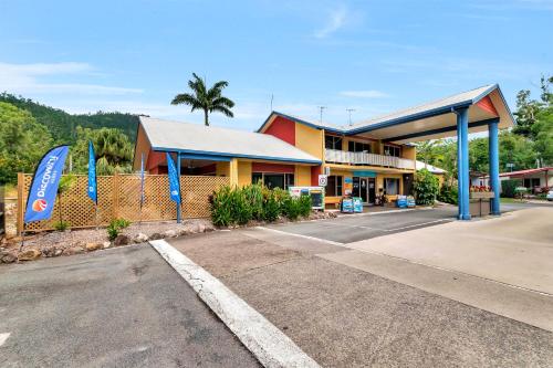 a gas station next to a road with a building at Discovery Parks - Airlie Beach in Airlie Beach