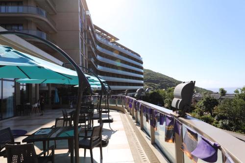 a balcony with tables and chairs and a building at Pinxiayuan Apartment in Lvcheng Resort in Zhoushan