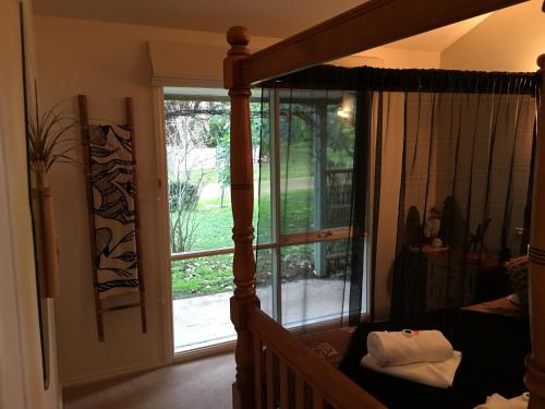 a bedroom with a bed and a glass door at Weeroona Bed And Breakfast in Rye