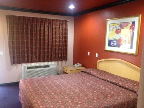 una camera d'albergo con letto e finestra di All 8 Motel ad Azusa