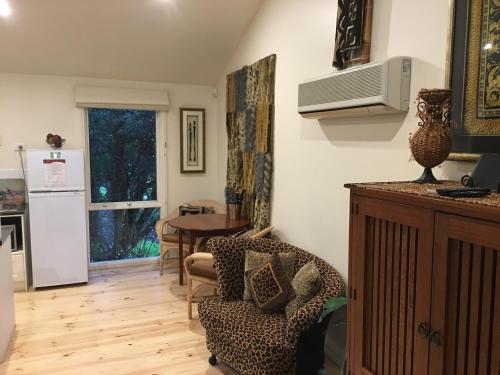 a kitchen and living room with a table and a chair at Weeroona Bed And Breakfast in Rye