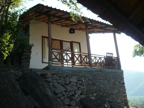 a house with a stone wall and a balcony at Wawa Wewe Rock in Amed