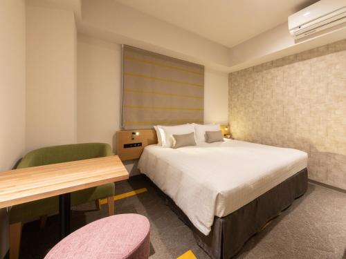 a hotel room with a bed and a desk and chair at Tokyu Stay Sapporo Odori in Sapporo