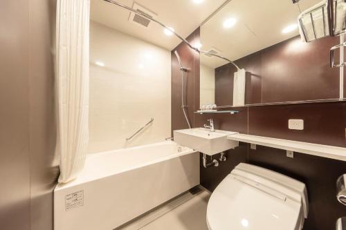 a bathroom with a toilet and a sink and a tub at Tokyu Stay Sapporo Odori in Sapporo