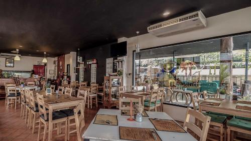 un restaurante con mesas y sillas y una gran ventana en Bandahara, en Satun