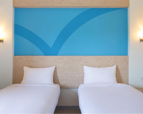 two beds sitting next to each other in a room at Hop Inn Hotel Ermita Manila in Manila