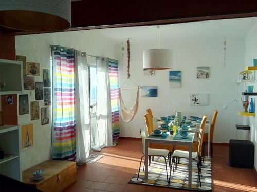 a dining room with a table and chairs at Fonte da Telha Beach Hostel in Costa da Caparica