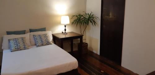 SilangにあるMarius B&B & Hostelのベッドとランプ付きのテーブルがある寝室