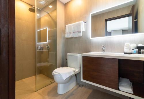 La salle de bains est pourvue de toilettes, d'un lavabo et d'une douche. dans l'établissement Ramada Encore by Wyndham Makati, à Manille