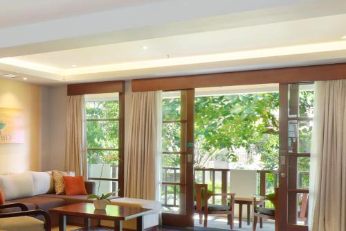 a living room with large windows and a couch at Novotel Bali Nusa Dua in Nusa Dua