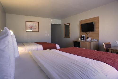 a hotel room with two beds and a television at Aladdin Inn and Suites in Portland