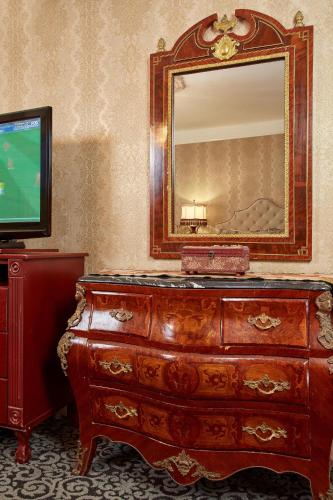 a dresser with a mirror and a television in a room at Queen Anne in San Francisco