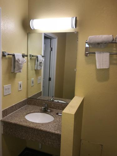 a bathroom with a sink and a mirror at Colony Inn Motel in Bellflower