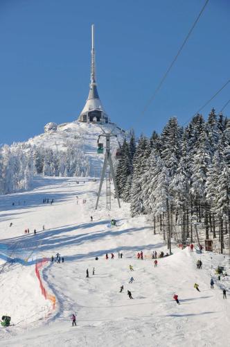 un grupo de personas esquiando por una pista de esquí con remonte en Hotel Ještěd, en Liberec