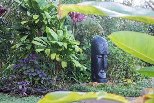 a black statue in the middle of a garden at Channers on Norfolk in Burnt Pine