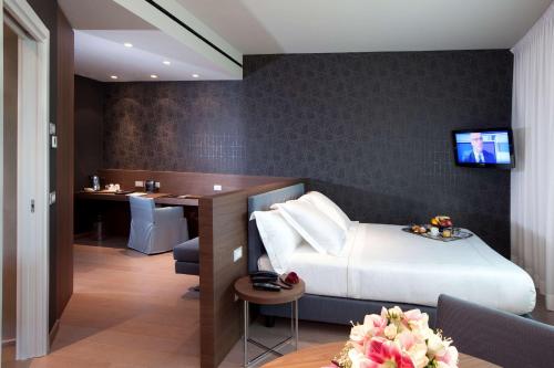 a hotel room with a bed and a desk at Devero Hotel & Spa, BW Signature Collection in Cavenago di Brianza
