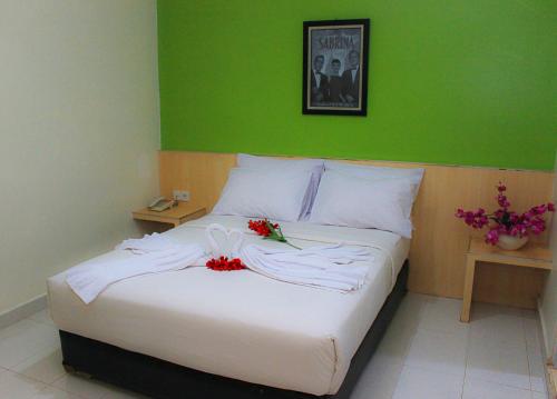 Un dormitorio con una cama blanca con flores. en Sabrina Paninsula, en Pekanbaru