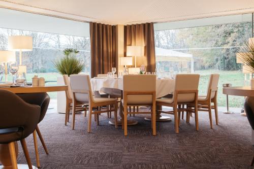 a dining room with a table and chairs at Best Western Le Bois de la Marche in Poitiers
