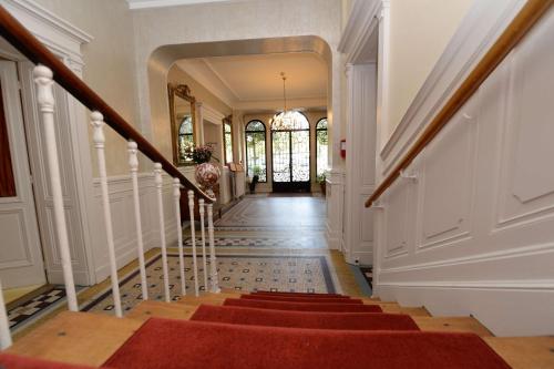 a hallway of a home with a red staircase at Best Western Hôtel de France in Bourg-en-Bresse