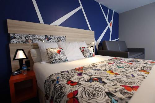 a hotel room with a bed and a chair at Best Western Hotel De Paris in Laval