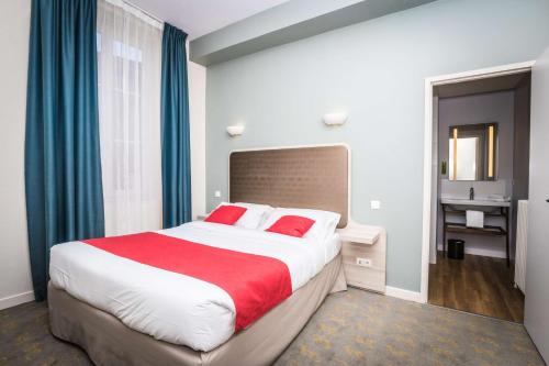 a hotel room with a large bed with red pillows at Best Western Hôtel de France in Bourg-en-Bresse