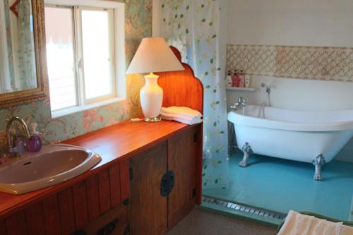 a bathroom with a tub and a sink at Minamiboso Asian Garden Villa Shirahama in Minamiboso