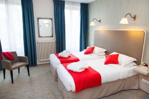 a hotel room with two beds with red and white pillows at Best Western Hôtel de France in Bourg-en-Bresse