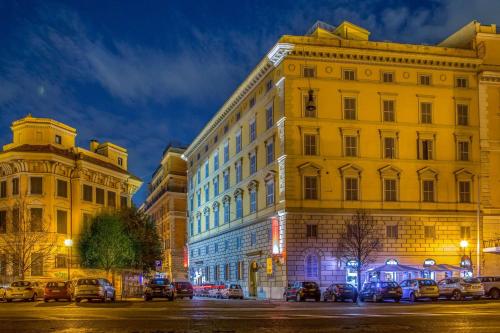 a yellow building on a city street at night at Hotel Canada, BW Premier Collection in Rome