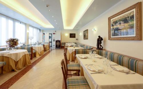 a restaurant with tables and chairs and a painting on the wall at Best Western Hotel Dei Cavalieri in Barletta
