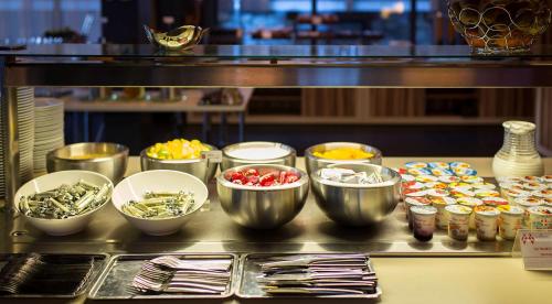 a buffet line with bowls of food on a table at Excelsior Chamonix Hôtel & Spa in Chamonix-Mont-Blanc