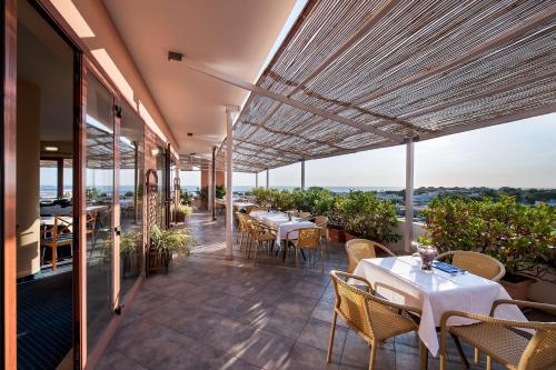 un restaurant avec des tables et des chaises sur un balcon dans l'établissement Hotel La Baia, à Bari
