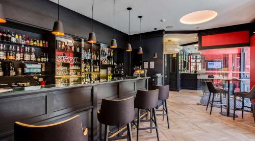 a bar with a bunch of chairs and a counter at Excelsior Chamonix Hôtel & Spa in Chamonix-Mont-Blanc