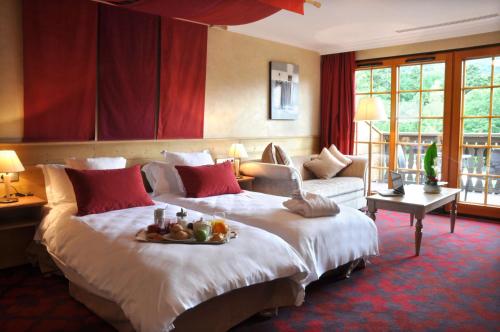 a hotel room with a bed with a tray of fruit on it at Les Violettes Hotel & Spa in Jungholtz