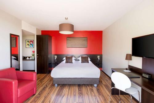 a hotel room with a bed and a red wall at Best Western Park Hotel Geneve-Thoiry in Thoiry
