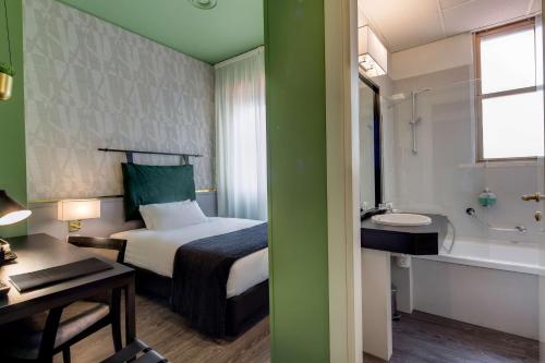 a bedroom with a bed and a bathroom with a sink at Best Western Plus CHC Florence in Florence