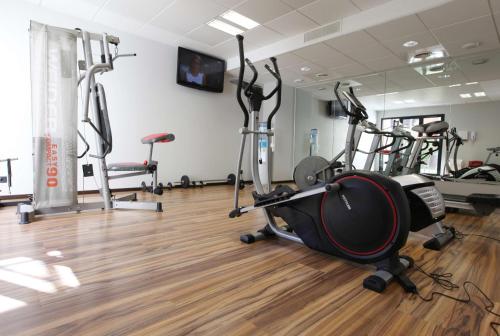 a gym with several treadmills and exercise bikes at Best Western Park Hotel Geneve-Thoiry in Thoiry