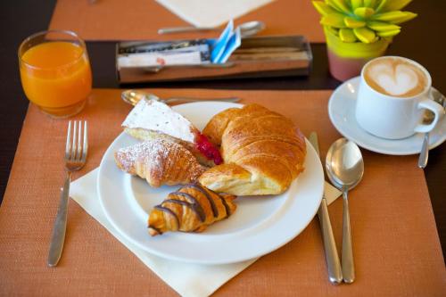 a plate of breakfast food with croissants and a cup of coffee at Best Western Crystal Palace Hotel in Turin