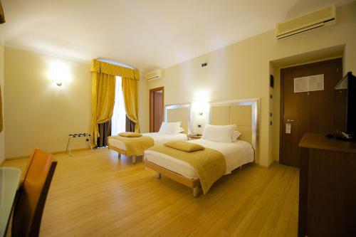 a hotel room with two beds and two chairs at Best Western Crystal Palace Hotel in Turin