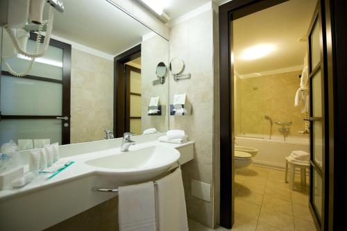 a bathroom with a sink and a tub and a toilet at Best Western Crystal Palace Hotel in Turin