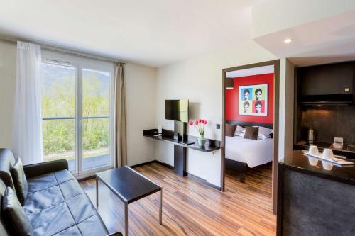 a living room with a couch and a bed at Best Western Park Hotel Geneve-Thoiry in Thoiry