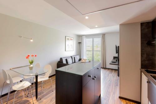 a kitchen and living room with a table and chairs at Best Western Park Hotel Geneve-Thoiry in Thoiry