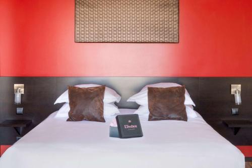 a bedroom with a bed with a book on it at Best Western Park Hotel Geneve-Thoiry in Thoiry