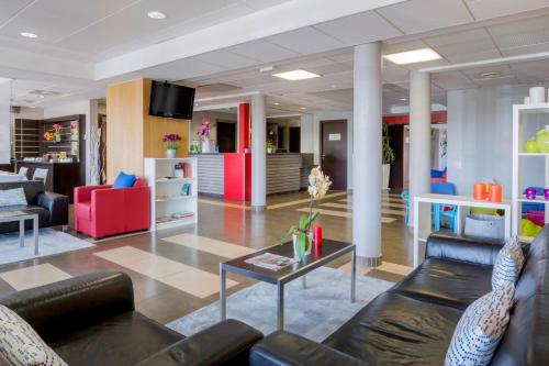 a living room with couches and a coffee table at Best Western Park Hotel Geneve-Thoiry in Thoiry
